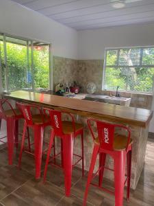a kitchen with red chairs and a wooden counter top at Santo Cristo in Tena