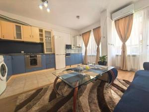 a living room with blue cabinets and a glass table at Hristean Apartment Petrich in Petrich