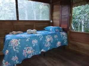 ein Bett in einem Zimmer mit einer blauen Bettdecke in der Unterkunft Altér Chale in Santarém + 16 Fotos