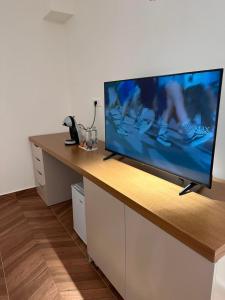 a flat screen tv sitting on top of a desk at Zac's Rooms in Dukat