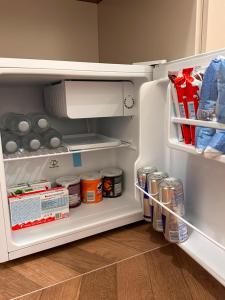 an open refrigerator filled with food and drinks at Zac's Rooms in Dukat