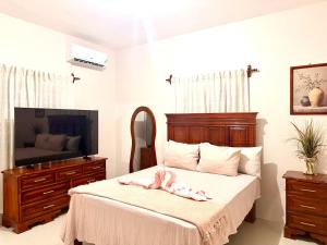 a bedroom with a bed with a pink ribbon on it at Olive Breeze III in Runaway Bay