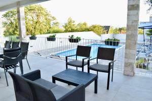 a patio with chairs and a table and a pool at Villa Blanco in Mostar