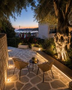 a patio with a table and chairs and a tree at Angela Studios in Syvota