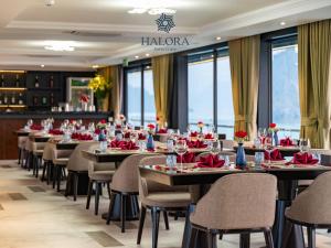 a dining room with tables and chairs with red napkins at Halora Kairos Cruise in Ha Long