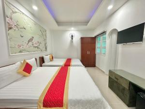 a bedroom with two beds and a tv at Phú Gia Hotel 464 Nguyễn Văn Linh in Ho Chi Minh City +19 photos