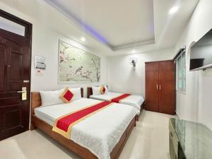 a bedroom with two beds and a tv in it at Phú Gia Hotel 464 Nguyễn Văn Linh in Ho Chi Minh City
