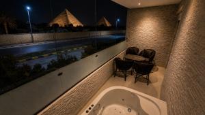 a bath tub in a room with a view of a pool at Dar Pyramids Boutique in Cairo