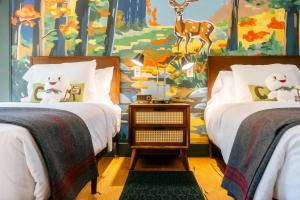 two beds in a bedroom with a mural at Camp DeForest in Lincolnville