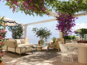 a patio with chairs and tables and flowers at Jumeirah Capri Palace in Anacapri