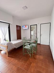 a bedroom with a bed and a table and chairs at Olivos Lujan in Luján