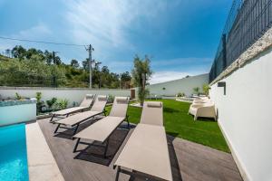 a row of tables and chairs next to a swimming pool at Casa do primo Zeca in Ponte da Barca