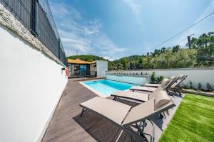 a patio with chairs and a swimming pool at Casa do primo Zeca in Ponte da Barca