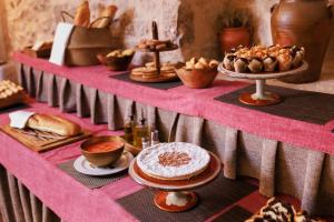 a table with bread and pastries on a pink table at Hotel de La Trucha in Villarluengo