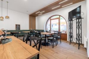 a restaurant with wooden tables and chairs and a large window at Penzion Eden Pálava in Klentnice