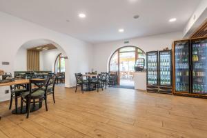 a dining room with tables and chairs and wine bottles at Penzion Eden Pálava in Klentnice
