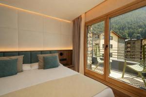a bedroom with a bed and a large window at Hotel Princesa Parc Excellence in Arinsal