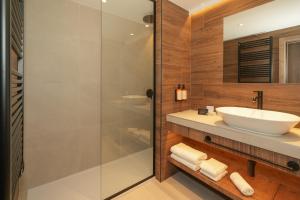 a bathroom with a sink and a glass shower at Hotel Princesa Parc Excellence in Arinsal