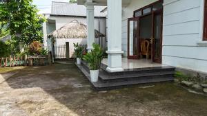 a white house with a porch and a door at Tay Na Bon Homestay in Ha Giang +9 photos