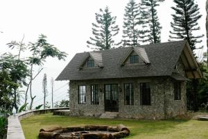 a stone house with a large tree log in front of it at The Old Country Stone House in Cebu City