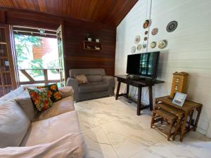 a living room with a couch and a television at Paz na Serra Teresopolis Pet Friendly in Teresópolis