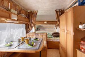 a dining area with a table in a rv at Caravane au jardin in Brix +13 photos