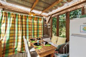 a table and chairs on the porch of a house at Caravane au jardin in Brix