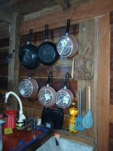 ein Haufen Töpfe und Pfannen hängen an einer Wand in der Unterkunft Altér Chale in Santarém