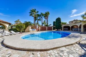 a swimming pool in a patio with chairs and a house at Villas Guzman - Xenia in Calpe