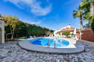 a swimming pool in a backyard with palm trees at Villas Guzman - Xenia in Calpe