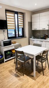 a kitchen with a white table and two chairs at Casa RUDOM in Aci SantʼAntonio