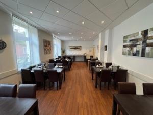 a restaurant with tables and chairs in a room at Hotel Jägerhof in Herne
