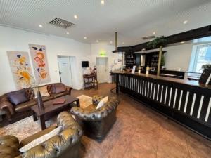a large living room with leather couches and a table at Hotel Jägerhof in Herne