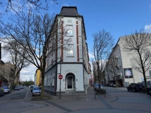 a tall building on a city street with a stop sign at Hotel Jägerhof in Herne