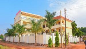 a building with palm trees in front of it at Coco Hotel Busia in Busia