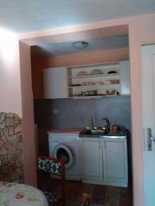 a kitchen with a washing machine and a sink at Bonbon Guest House in Panagyurishte