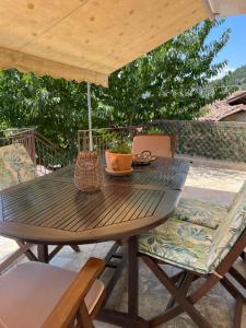 a wooden table and chairs under an umbrella at Forrest Guesthouse in Polídhroson