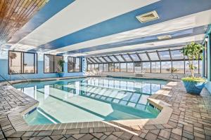a large swimming pool with blue walls and windows at Ocean Park Resort in Myrtle Beach +15 photos