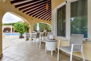 a patio with white chairs and a table and windows at Villas Guzman - Xenia in Calpe +66 photos