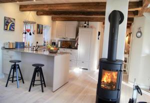 una cucina con una stufa al centro di una stanza di Ferienhaus nahe Ostsee mit Sauna, Kamin & eingezäuntem Garten,Hund willkommen a Rabenholz