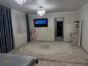 a bedroom with a tv on the wall and a bed at У Назгули in Cholpon-Ata