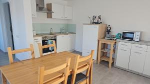 a kitchen with a wooden table and a microwave at Ferienwohnung An Der Kapelle in Rickenbach