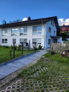 a white house with a fence in front of it at Ferienwohnung An Der Kapelle in Rickenbach