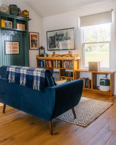 a living room with a blue couch and a book shelf at Camp DeForest in Lincolnville