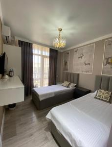 a hotel room with two beds and a chandelier at Qas-saQ in Türkistan