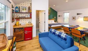 a living room with a blue couch and a bedroom at Camp DeForest in Lincolnville