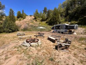 an rv parked in a field with a fire pit at Privet creek side glamping in Chase