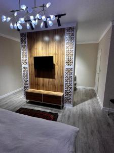 a living room with a tv and a bed in it at Qas-saQ in Türkistan