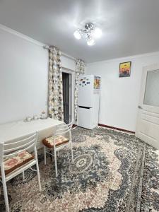 a kitchen with a table and chairs and a refrigerator at У Назгули in Cholpon-Ata