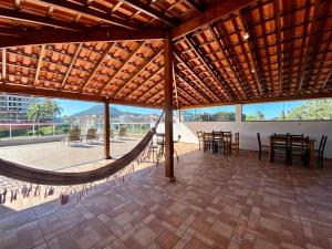 a large patio with a hammock in the middle at Pousada Werneck Residence Suites in Ubatuba